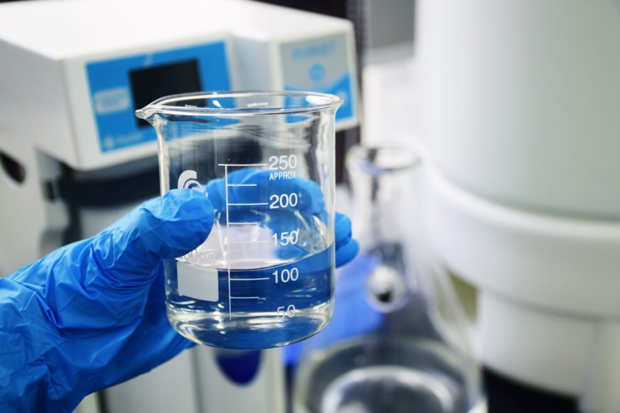 Person holding beaker of water in a lab
