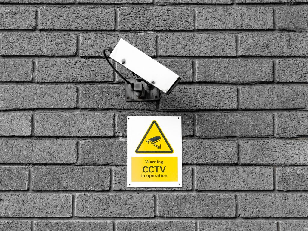 CCTV Camera on wall with notice underneath