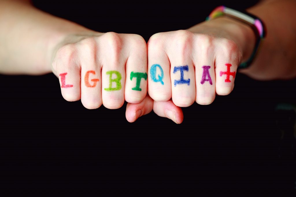 LGBTQIA+ Rainbow letters written across back of fingers