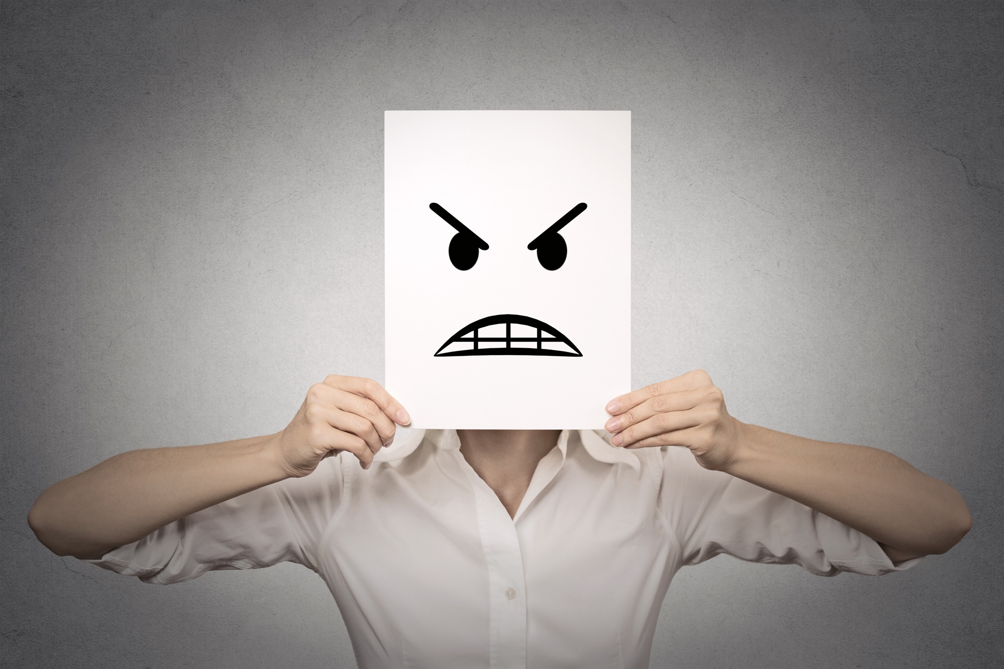 Woman covering her face with angry mask